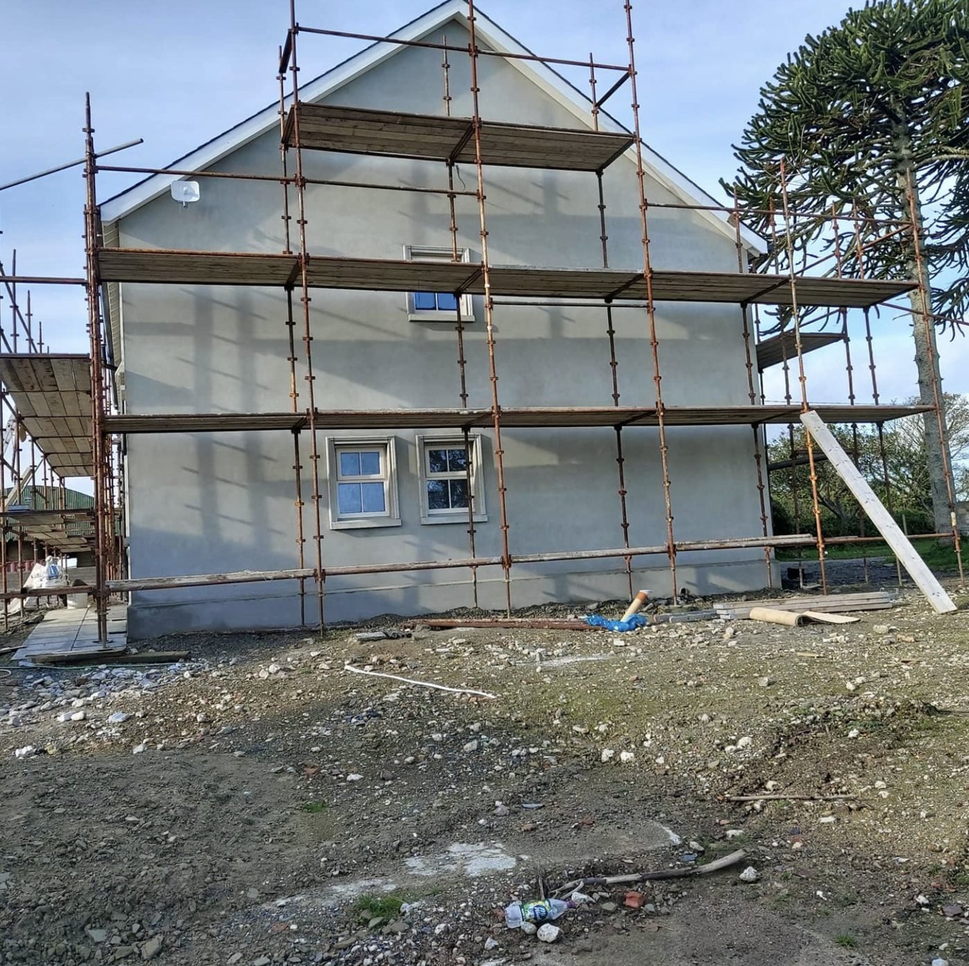 Gable wall in a grey basecoat with three levels of scaffolding