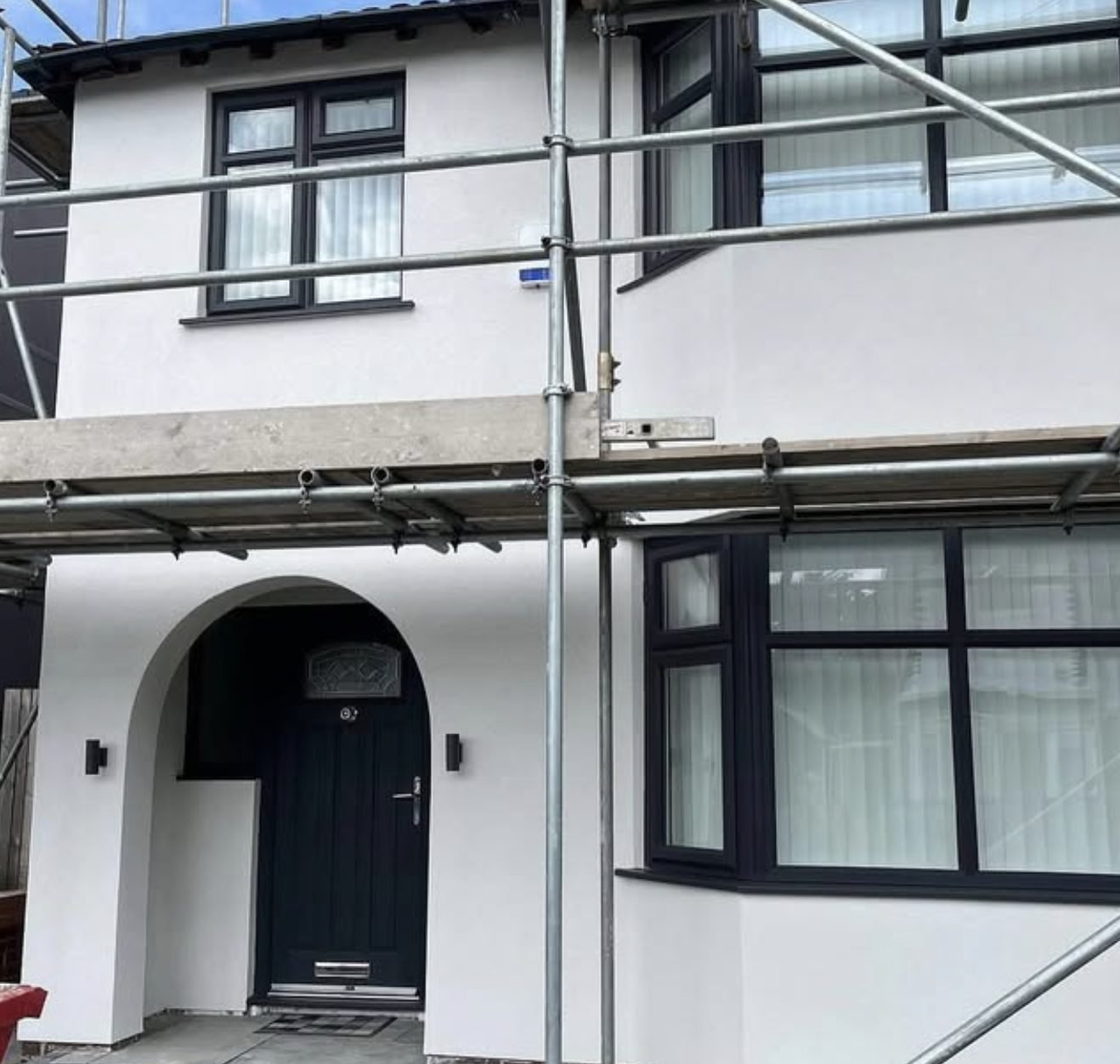Semi-detached house in a fresh white finish with scaffolding still in place