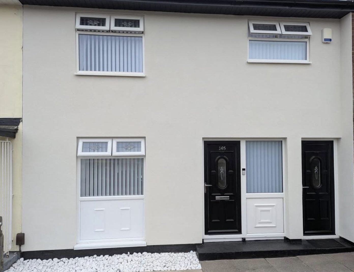 Two terraced house fronts in a matching smooth cream finish